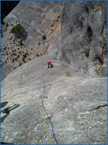 An unknown climber high on pitch-3 of Secreta Vida, F7a at Les Valls crag in the Els Ports Natural Park