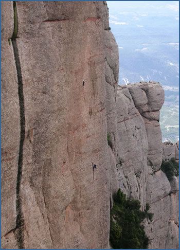 Climbers high on Valentin Casanovas (F7c or F6a-A0) at Paret de l’Aeril crag